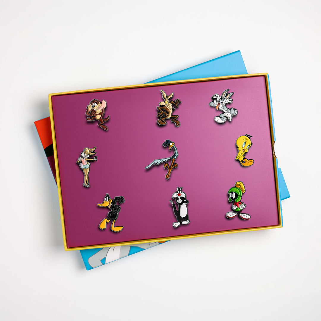 Open Looney Tunes box set tray displaying all 9 enamel pin badges in insert